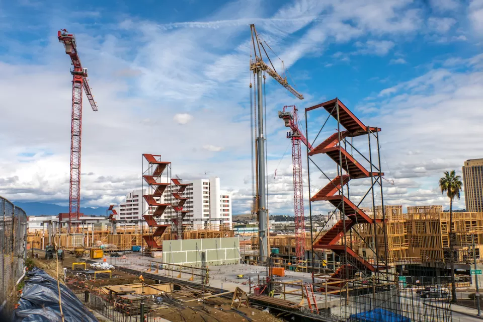 Large construction site with red staircases and cranes near downtown Los Angeles, California.